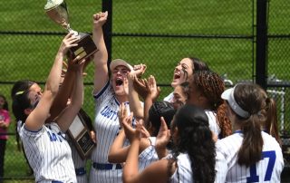 Abbott Softball players holding trophy.